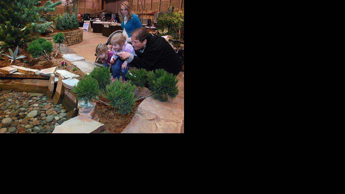 
Maggie Regier, right, points out a pond to granddaughters Cassidy and Liberty Busenitz and their mom, Bonnie, at the Outdoor Living & Landscape Show on Saturday at Century II. 
