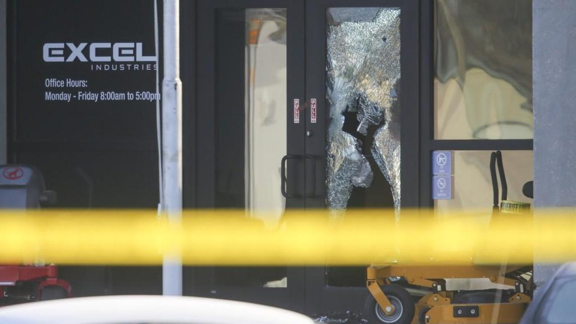 A shattered window can be seen at the main entrance to Excel Industries in Hesston as investigators continue to work inside the building on Friday morning. Cedric Ford entered the factory and killed three people and wounded over a dozen others a day before.