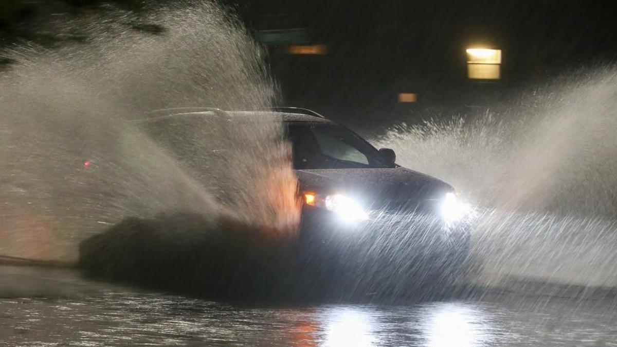 A car passes through a flooded street in the Delano area in Wichita on Tuesday night. Wichita and all of Sedgwick County are under a flood warning.