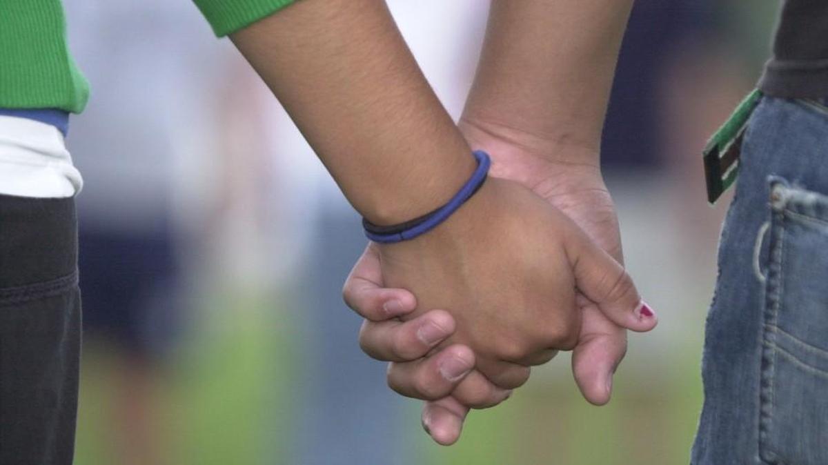 Two Wichita East High School students hold hands and pray at the  school's flag pole during a past "See You at the Pole" prayer event.