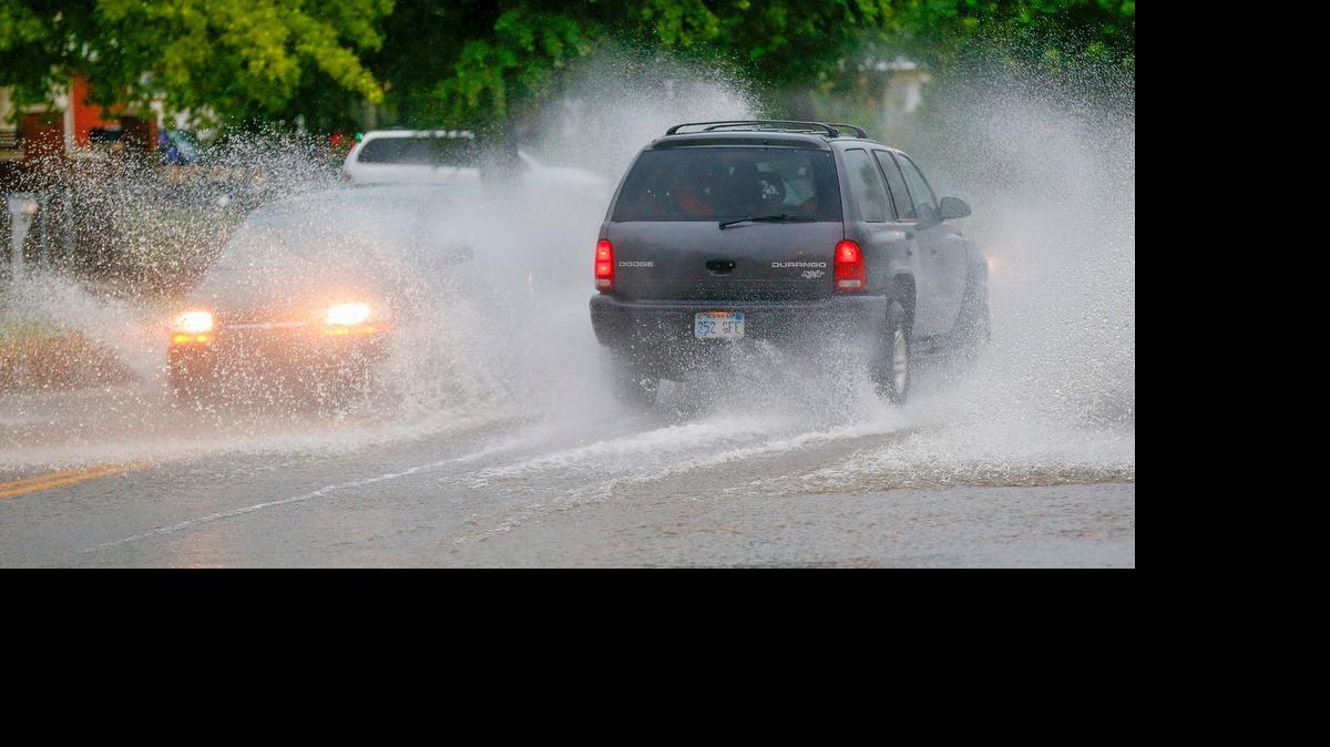
Cars traverse a flooded street on West Douglas. (May 23, 2015)
