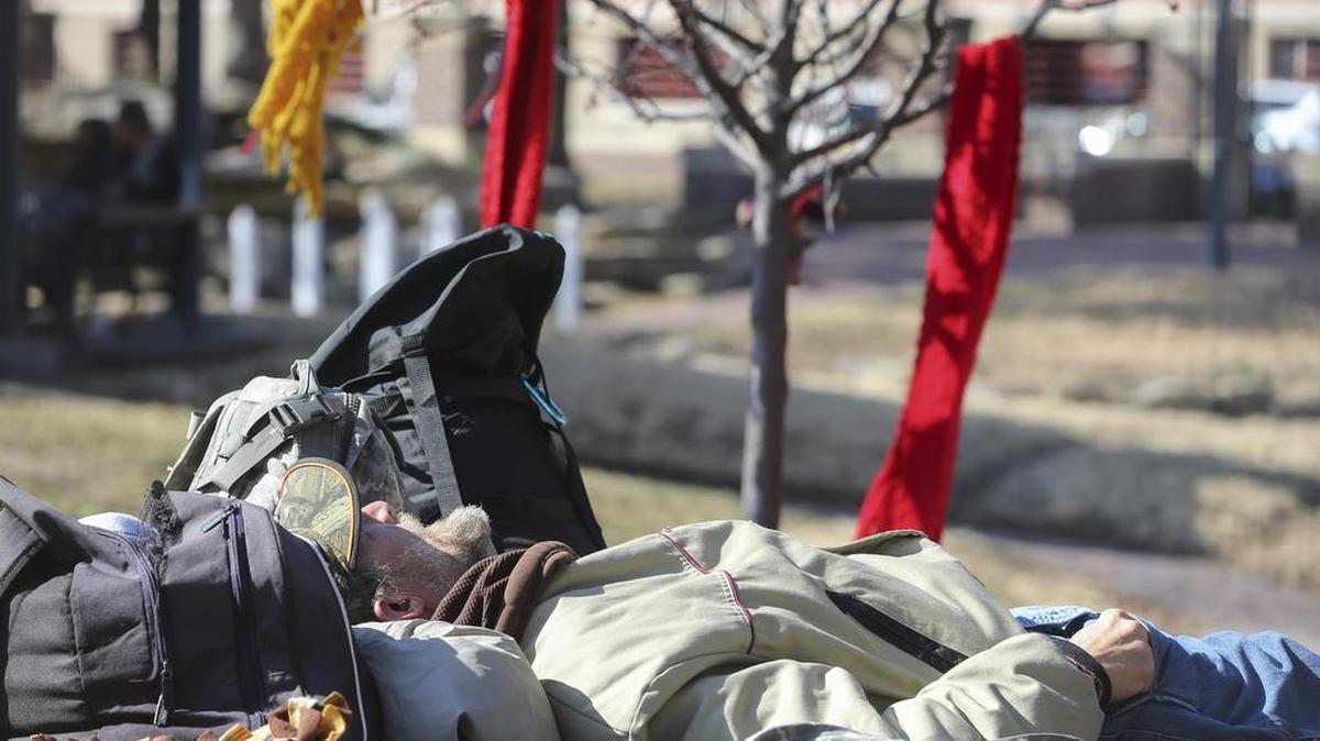 A man rests in Naftsger Park.