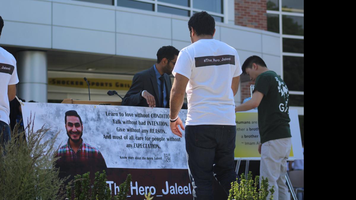 
A banner bearing Abduljaleel Alarbash’s picture is hoisted before a candlelight vigil in his honor Friday afternoon at Wichita State University.
