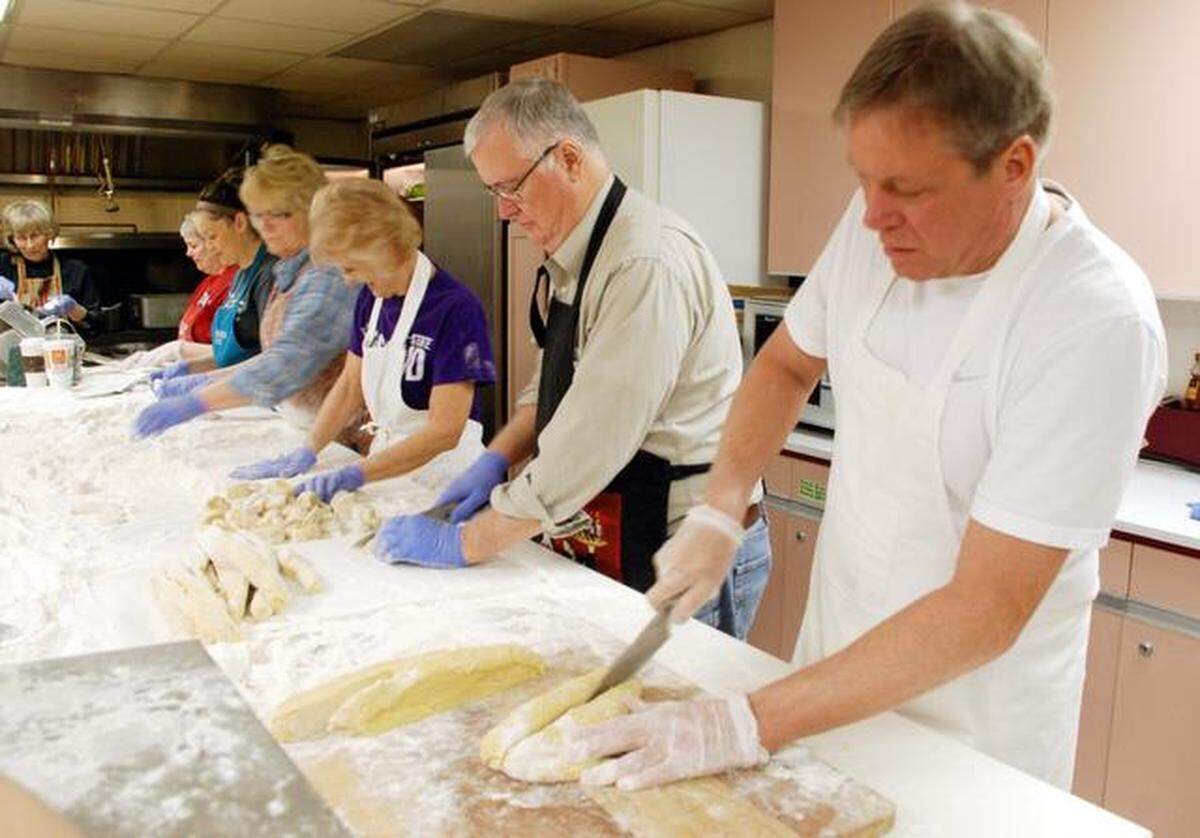 Church volunteers form an assembly line to cut and pound down dough for noodles at the 2015 St. Paul’s United Methodist Church Chicken Noodle Dinner.