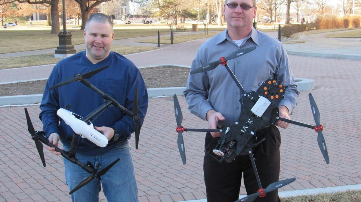 Jason Klenklen, left, and Tim Vice of Westar Energy hold the two aerial drones the power company is preparing to deploy. The drones will be used to find problems with transmission lines and inspect blades on the company’s wind turbines.