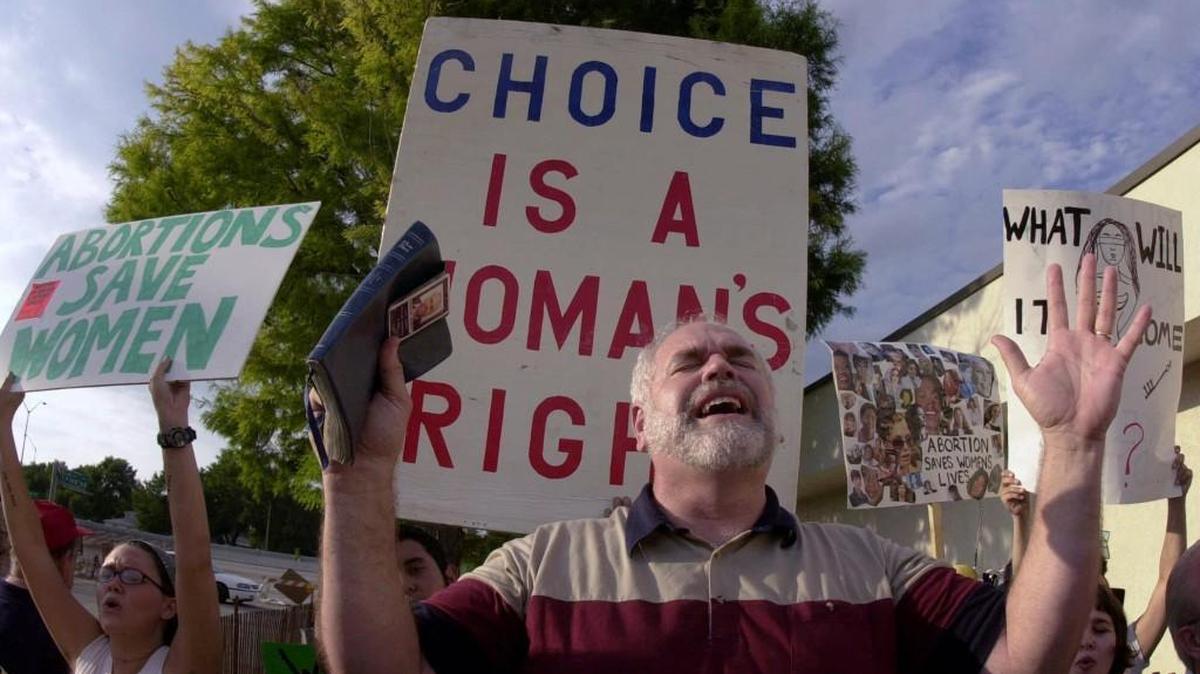 Anti-abortion protester Leon Hiebert sings a hymn while abortion-rights activists protest in 2001 at a weekend rally held by Operation Save America.