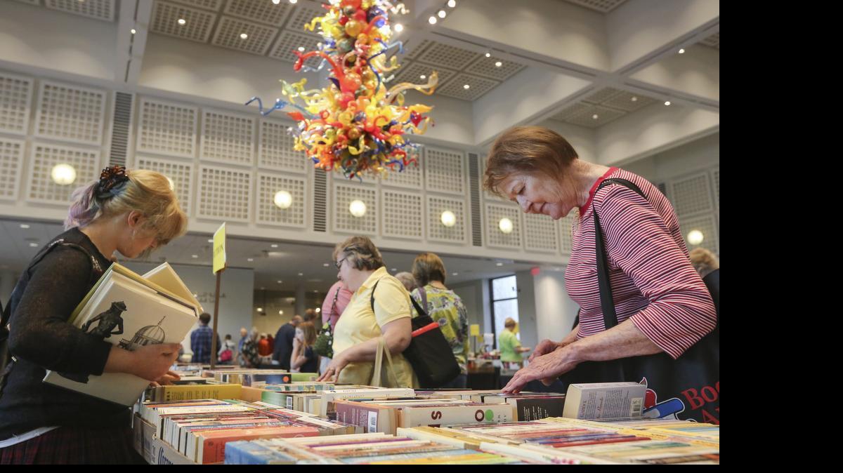 
Willodean Swords, right, and Cecilia Ferris browse through book titles at the Art and Book Fair at the Wichita Art Museum on Saturday. 
