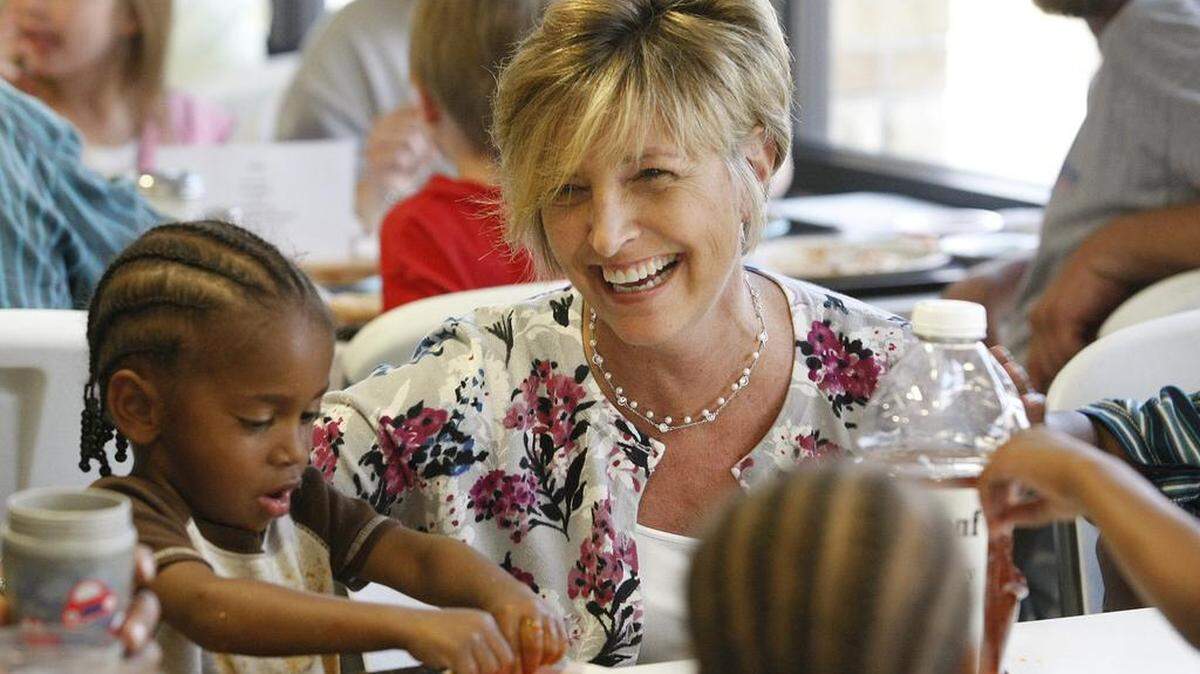 Wendy Glick talks with people eating dinner in 2011 at the Lord’s Diner. Glick is the new executive director of Catholic Charities.