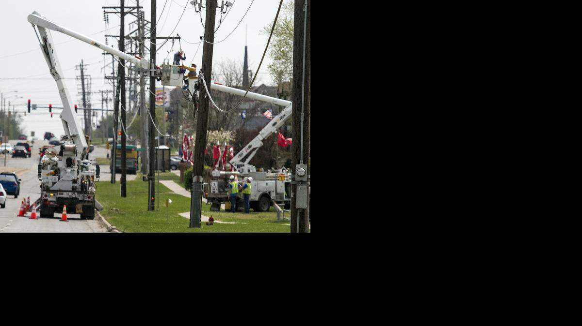
Utility workers repair damage to utility poles, power and cable lines along Woodlawn between K-96 and 21st Street. (April 6, 2015)
