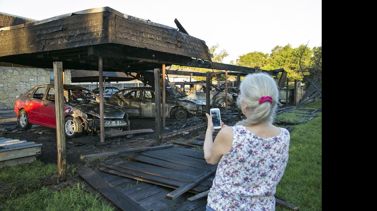 
Connie Schmidt photographs her red Ford Focus that was destroyed in a carport fire at La River condominiums early Monday morning. While the cause of the fire is under investigation, Schmidt said residents have had problems with vandalism in the past. (June 8, 2015) 
