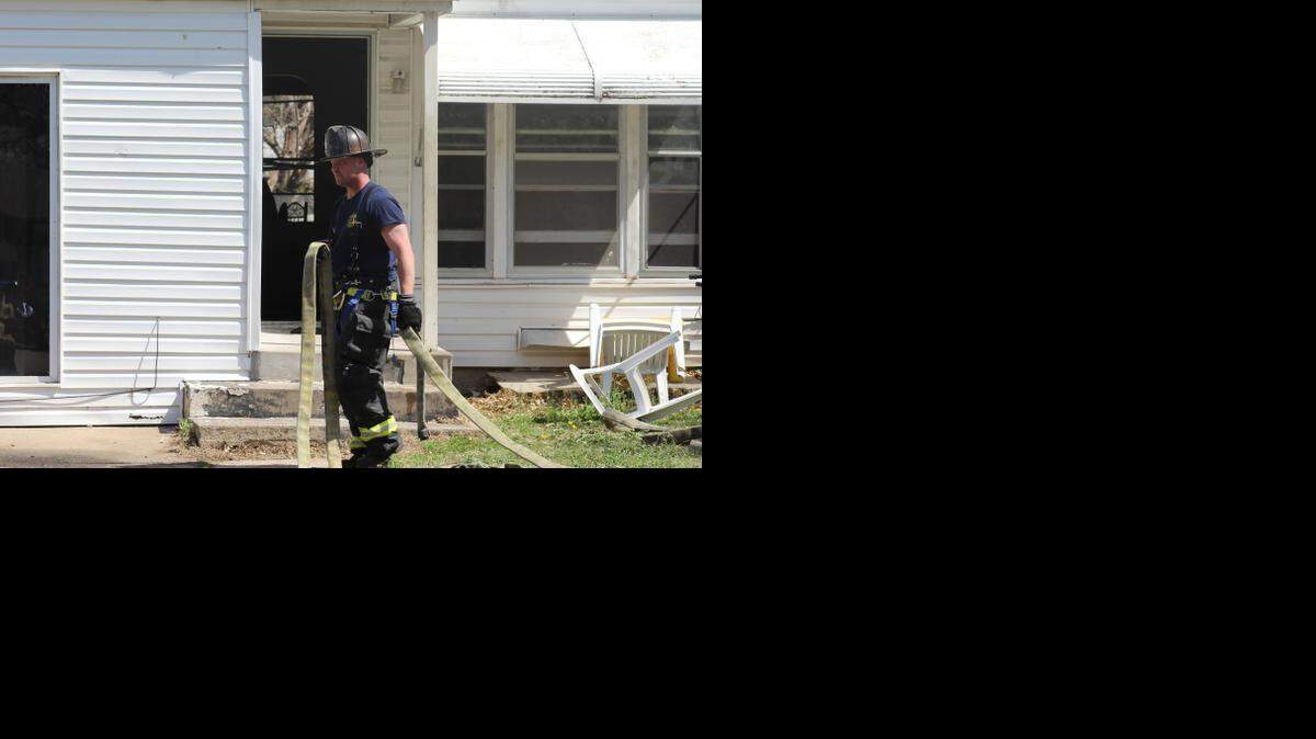 
Wichita firefighters clean up after a house fire in the 1000 block of North Pershing on Saturday. A man was rescued through a rear window of the house.
