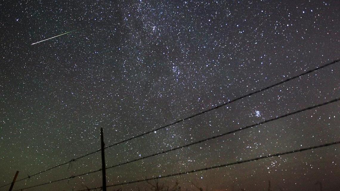 In this file photo from Aug. 13, 2013, a meteor streaks past the faint band of the Milky Way galaxy above the Wyoming countryside during a Perseids meteor shower. On Thursday night, Aug. 11, into early Friday morning, the Perseid meteor shower is expected to peak with double the normal number of meteors. Scientists call this an outburst, and they say it could reach up to 200 meteors per hour.