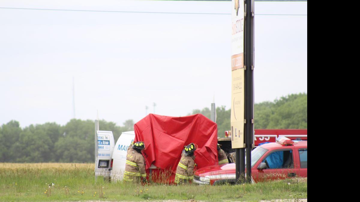 
Andover firefighters remove a tarp from a van that caught fire after rear-ending a semi in Andover. The driver was pronounced dead at the scene.
