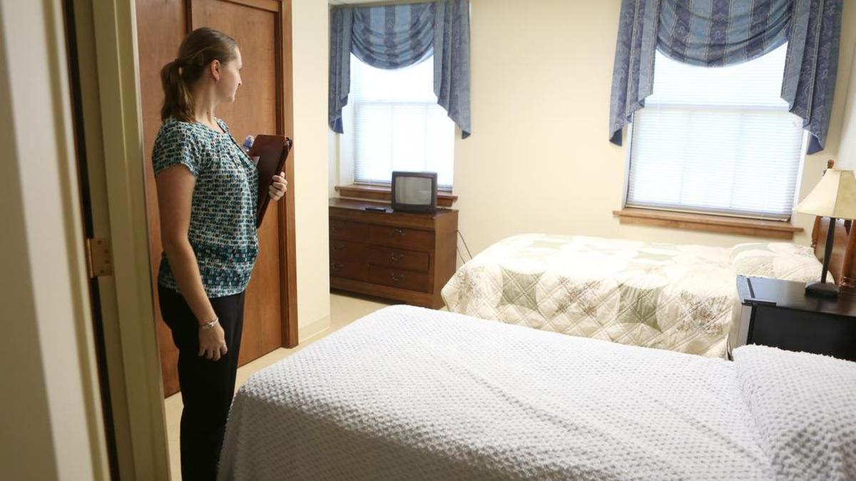 
Jen McGill, housing services program director with Catholic Charities, looks over a two-bed room at the Mount on East Lincoln. Harbor House and Anthony Family Shelter will send families and domestic violence victims to the Mount and it will have 14 rooms available in this first stage. (Oct. 6, 2015)
