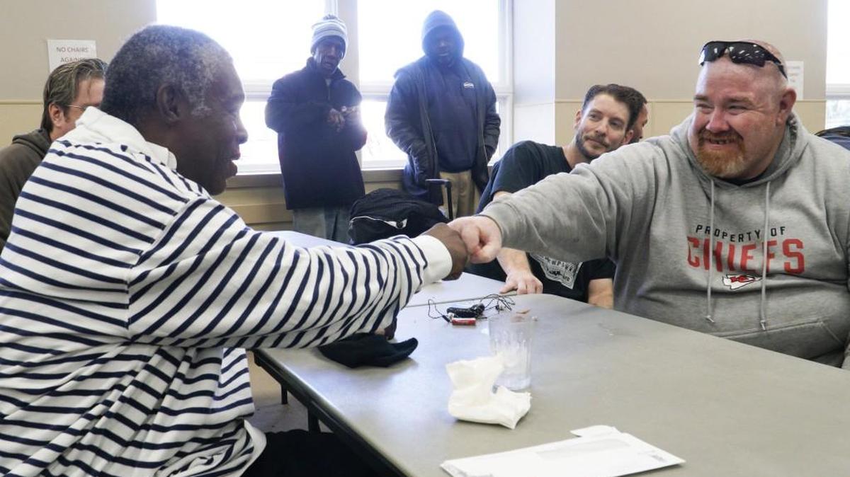 Gracen Guise, left, exchanges a fist-bump with Robert Parker during lunch Thursday at the United Methodist Open Door’s Homeless Resource Center. Parker is a former client who wanted to give back to the center, so he helped serve chicken dinners to current clients. (Nov. 10, 2016)