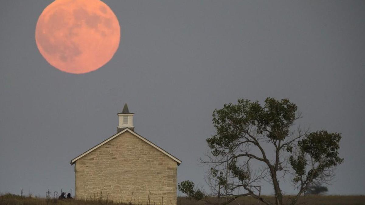 
A supermoon rises Sunday night over the Lower Fox Creek School near Strong City. The supermoon later underwent a total lunar eclipse. The Lower Fox Creek School is a one-room schoolhouse built in 1880 that is now part of the Tallgrass National Prairie Preserve.
