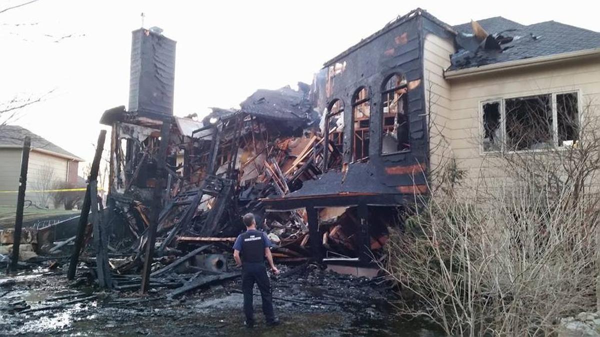 A fire investigator looks at the damage to a house in west Wichita that sustained over $600,000 damage.