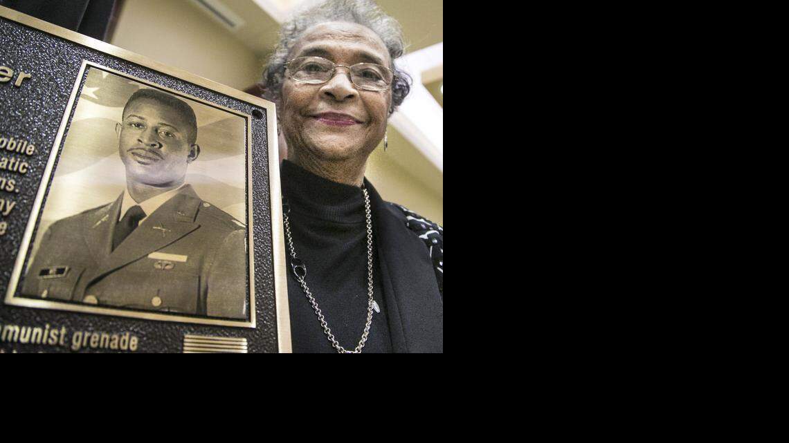 
Eula Pitts, widow of University of Wichita alumnus Riley Pitts, stands with the plaque that will hang in Wichita State University’s Military and Veteran Student Center, named in his honor. (Nov. 7, 2014)
