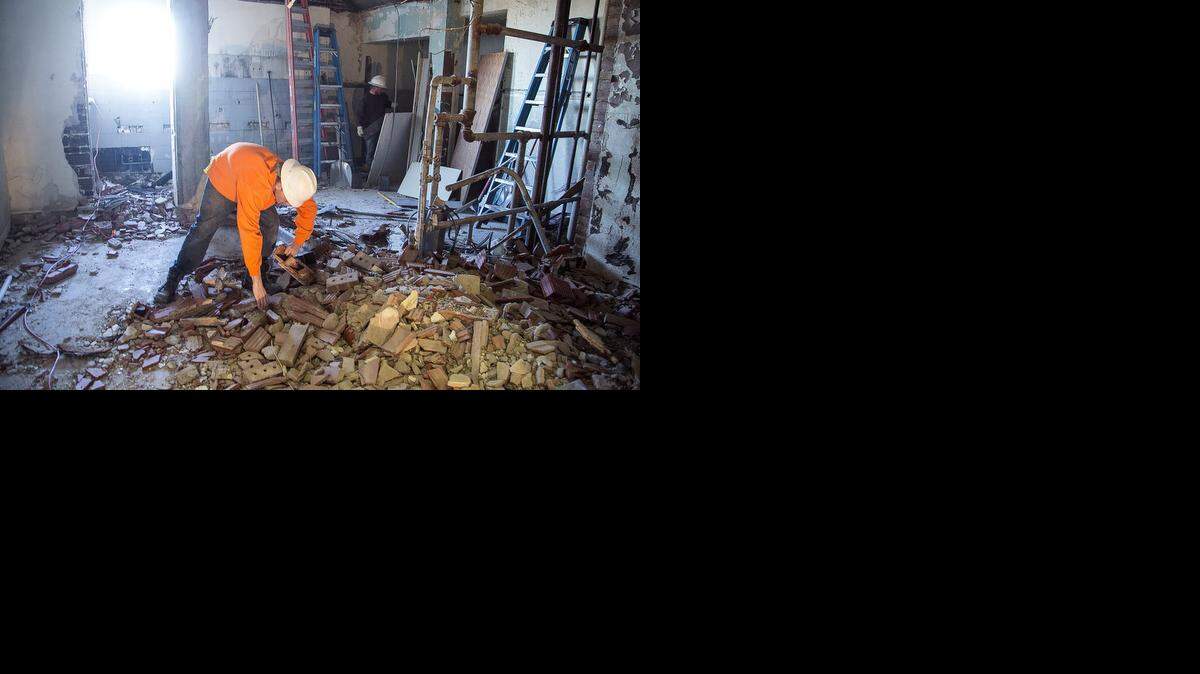 
Johnny McCoy, foreground, and Jimmy McGuire, both of H.D. Mills & Sons Excavation and Wrecking, demolish the original women’s restroom at the Kansas Aviation Museum so it can be remodeled as a men’s restroom. (Dec. 16, 2014)
