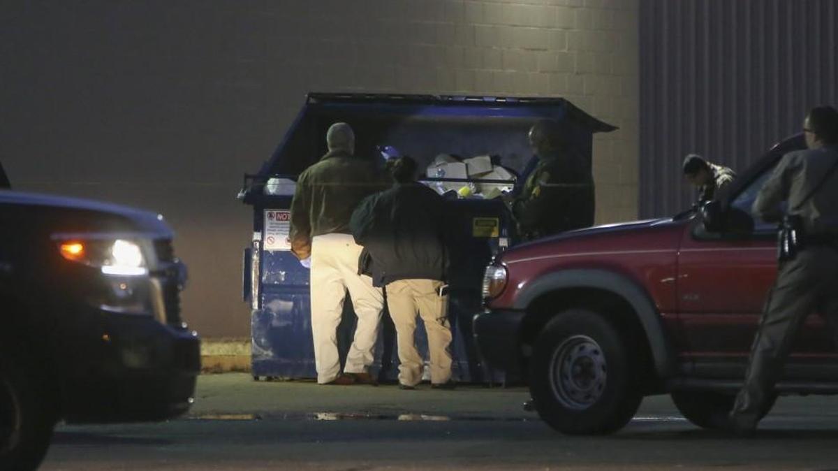 Police investigate a garbage dumpster in the 2000 block of west Harry where people digging through the dumpster discovered a body on Sunday.