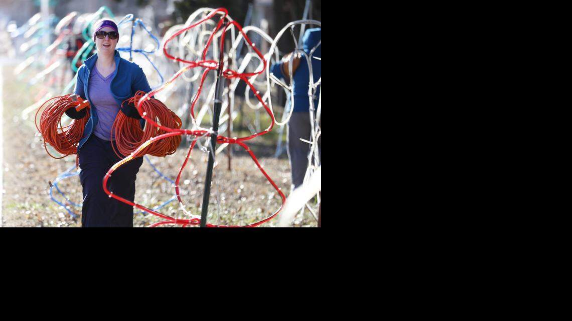 
Laura Bernstorf carries rolls of extension cords Monday morning as volunteers dismantled the Arc of Sedgwick County’s Lights on St. Paul display.  (Dec. 29, 2014)
