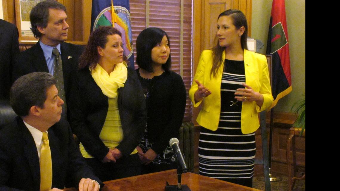 
Karen Countryman-Roswurm, right, executive director of Wichita State University's Center for Combating Human Trafficking, discusses a new state law designed to fight the problem, as Gov. Sam Brownback, lower left, and other supporters watch. (March 22, 2013) 
