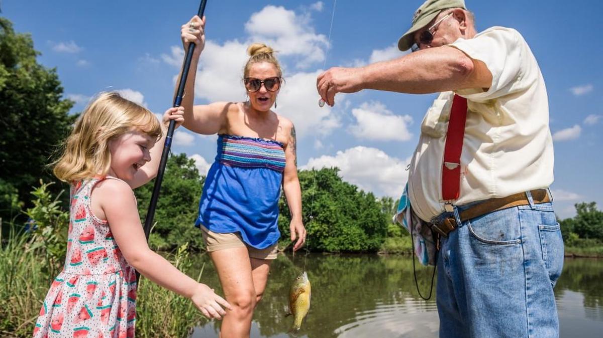 Volunteer Gale Brown holds a fish caught by Penny Diekemper and her mother, Angela Diekemper, on Saturday afternoon at the Great Plains Nature Center during The Eagle’s fishing clinic. The annual event was sponsored by The Wichita Eagle and the Kansas Department of Wildlife, Parks and Tourism, with assistance from the Flatland Fly Fishers Club and other volunteers.(June 11, 2016)