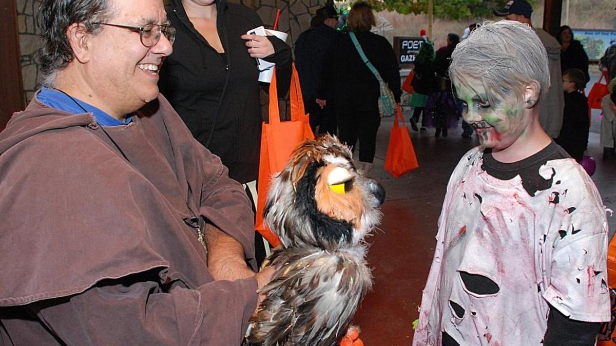 Volunteer David Moreno amused kids like Gauge Morgan with an owl puppet at “Night of the Living Zoo.”