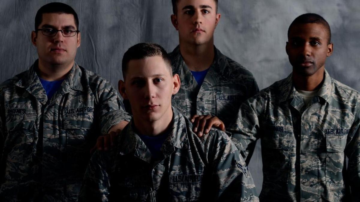 Three 22nd Air Refueling Wing Public Affairs airmen reach out to Airman 1st Class Christopher Thornbury, front.
