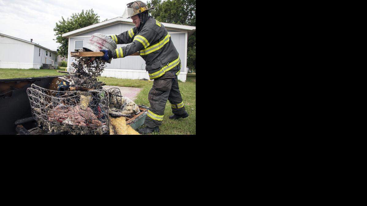 
Wichita firefighters help residents clean up after a fire engulfed a bedroom in a mobile home on South Hydraulic. (Sept. 2, 2014)

