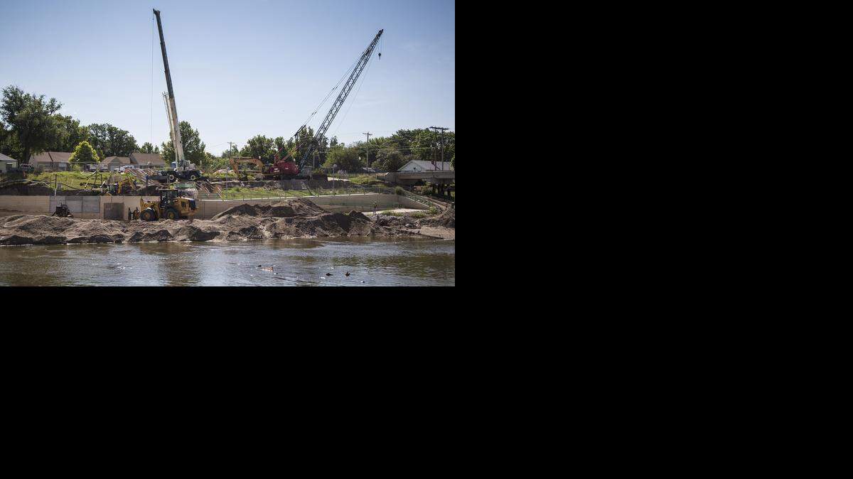 
Workers reconstruct the retaining wall along the Arkansas River south of the Lincoln Street Dam. Heavy rains a year ago caused erosion to soil underneath the sidewalk along the east bank, just south of the dam. 
