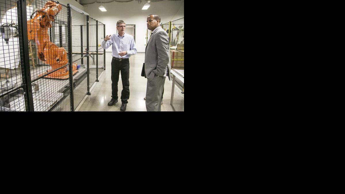 
Jay Williams, right, the U.S. assistant secretary of commerce for economic development, talks with WSU/WACT robotics instructor Bruce Handyside during a tour the National Center for Aviation Training. Williams announced a $1.9 million grant to WSU Friday.
