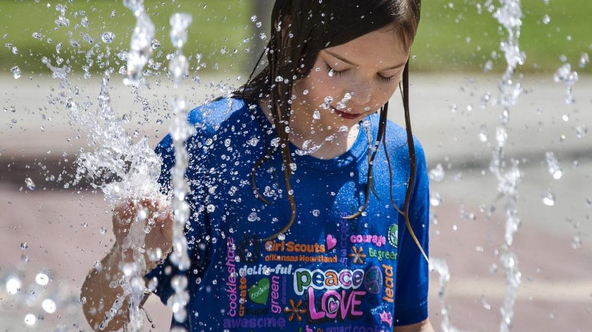 A 9-year-old girl cools off in the fountains at Central Riverside Park, getting some relief from the near triple-digit temperatures. (Aug. 26, 2014)