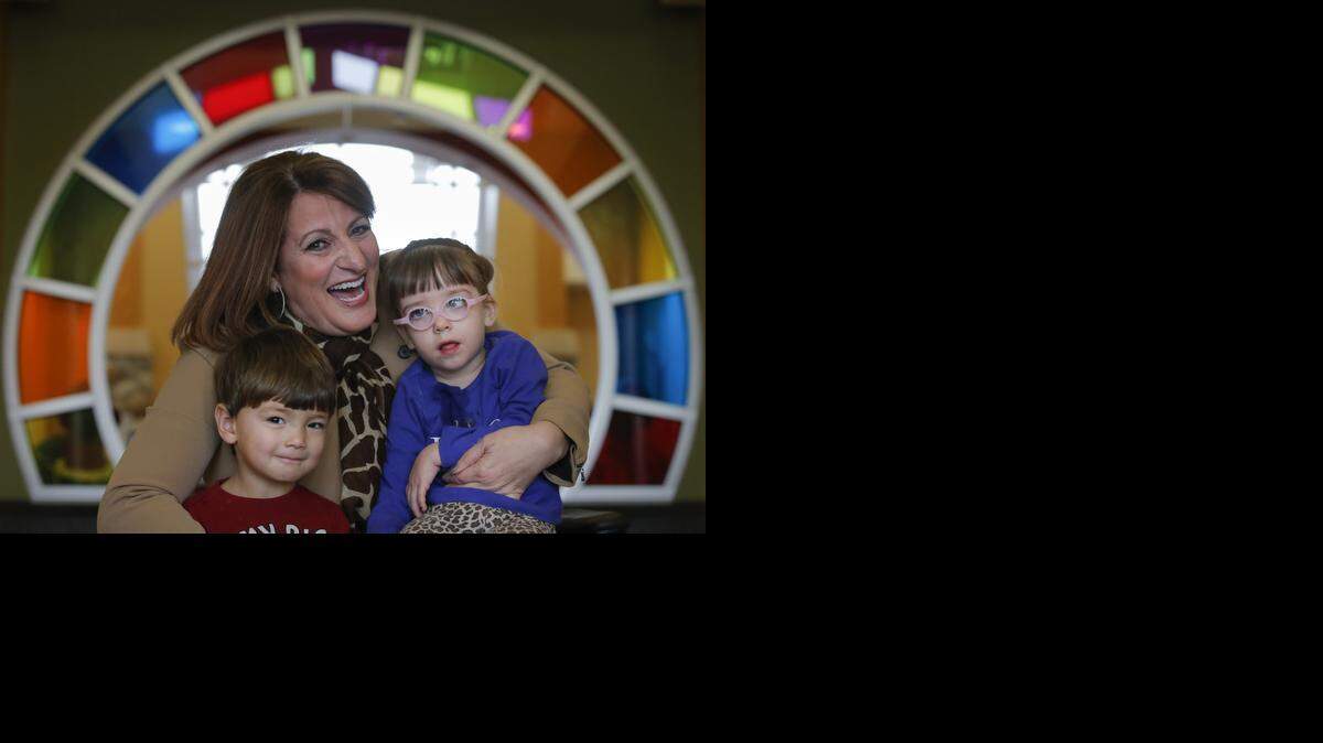
Jo Walters, who volunteers at Rainbows United, holds Tara Lutchka and Corbin Little. 
