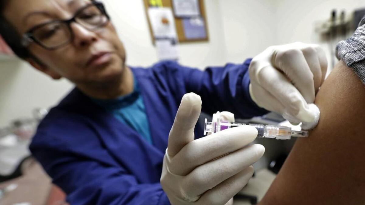 Ana Martinez, a medical assistant in Seattle, gives a patient a flu shot in Seattle. Nearly 50 deaths in Kansas have been contributed the flu so far this season, the Kansas Department of Health and Environment reports.