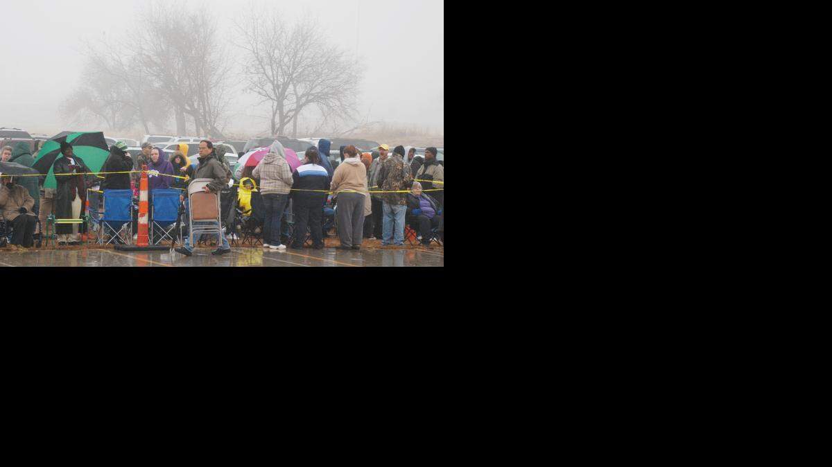 
People wait in line Saturday morning to pick up food at the Bread of Life Thanksgiving food distribution. 
