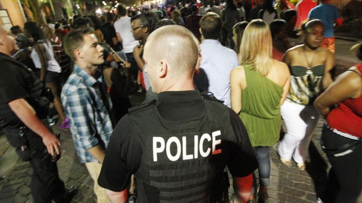 A Wichita police officer stands among a large crowd of people at closing time in Old Town in 2012.