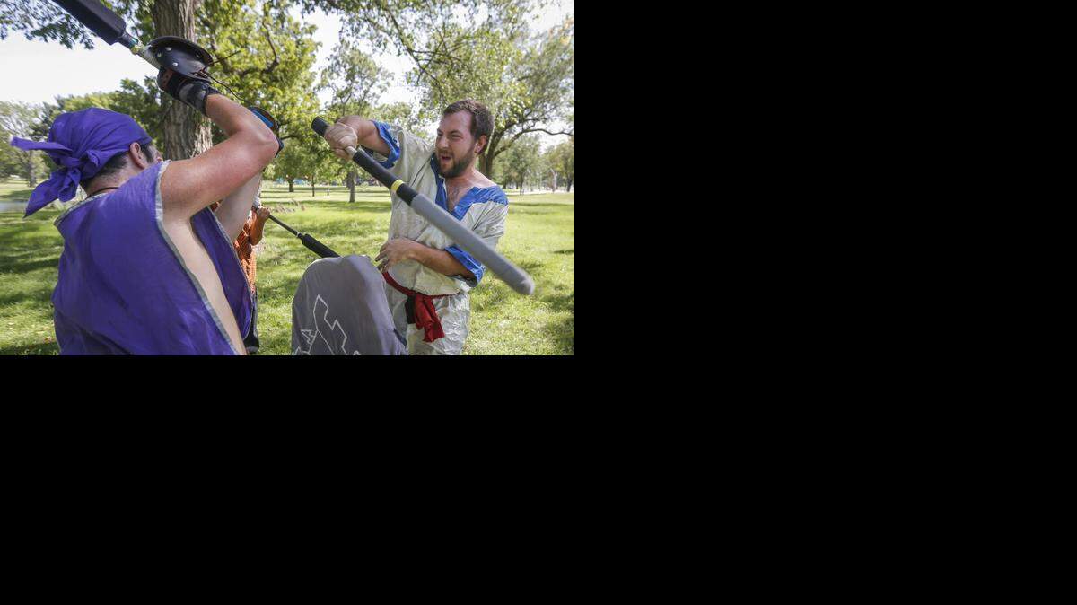 
Eric Simoncic, left, and Andrew Walker, both members of the Midwest Dagorhir Union – a role-playing combat organization – battle Saturday with foam weapons at Riverside Park. Members of the live action role playing group try to meet every weekend to practice their combat skills.
