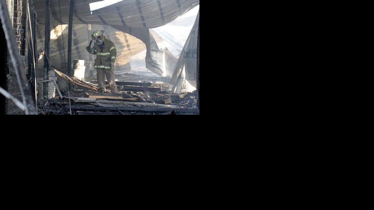 
Augusta Fire Department Lt. Tim Follis investigates an overnight stable fire at Palmer Ranch west of Augusta Monday morning. About 20 horses escaped injury, said Joe Pierce who was boarding two horses at the stable. (Jan. 5, 2015)
