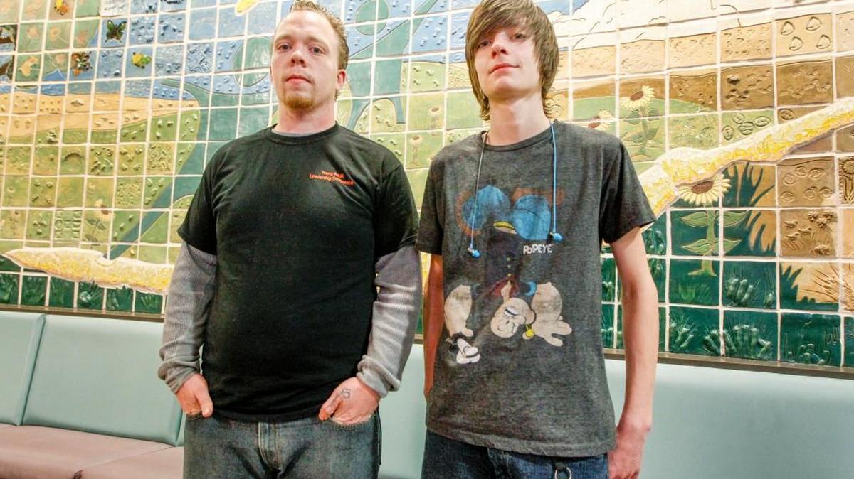Kevin Benson, left, and Samuel Carlisle pose in front of the Big Brothers Big Sisters mural in the lobby of the building in 2015. Both were part of the juvenile expungement program.