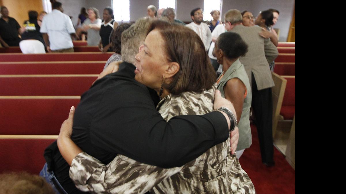 
Charlezetta Nixon, right, hugs Brandon Rhodes after a prayer vigil in response to the killings in Charleston, N.C. at the St. Paul AME Church in northeast Wichita Thursday. (June 18, 2015) 
