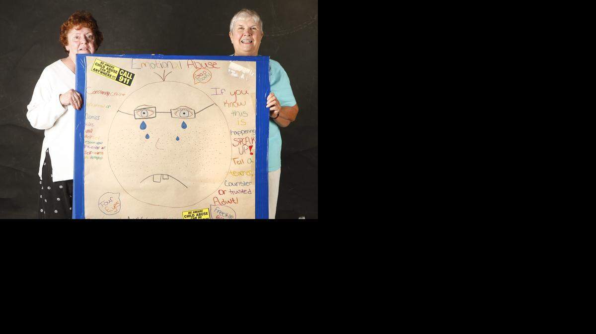 
Lily Hill, left, and Beverly Van Es hold a drawing children made to make other children aware of child abuse. (Oct. 22, 2014)
