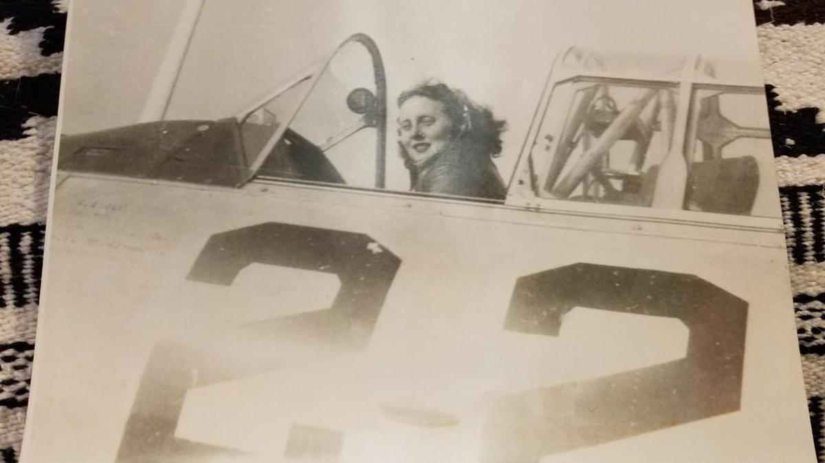 Meriem Lucille “Roby” Anderson waving from the cockpit of an AT-6, a plane used to train World War II pilots.
