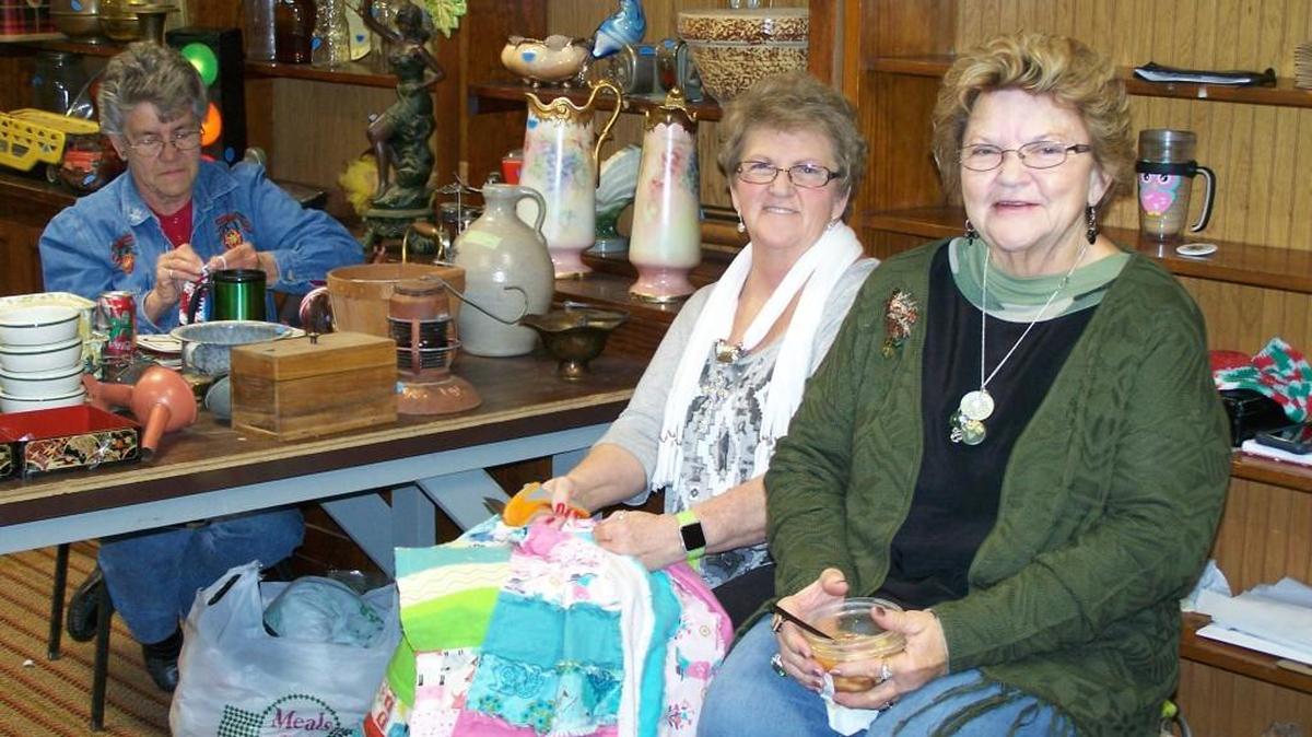 From left, Shirley Winchell of Haysville and sisters Donna Wunderlich and Kathy Simmons of Atlanta, Kan., kill time Saturday at Oxford’s Christmas in the Country. They had hoped to sell more of their crafts, but icy rain kept visitors away.