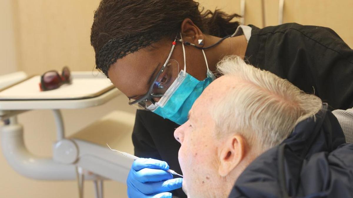 Kesha Patton, a dental assistant with GraceMed, works with a patient at the clinic on North Topeka in 2012. Services at the new GraceMed clinic at West High School will include preventive oral health care.