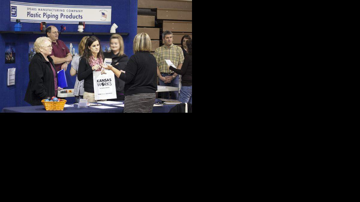 
Samantha Graves, center, talks with a prospective employer at a job fair in Coffeyville. The community is feeling the impact of the coming Amazon.com layoffs. About 600 workers at the Amazon warehouse, including Graves, will be laid off when it closes after the first of the year. (Nov. 20, 2014)
