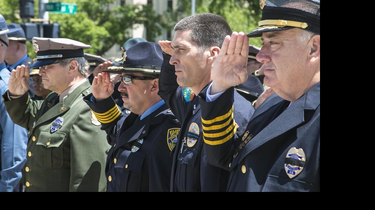 
Wichita police and Sedgwick County sheriff’s officers salute during taps Friday at the Law Enforcement Memorial service outside Wichita City Hall. (May 15, 2015)
