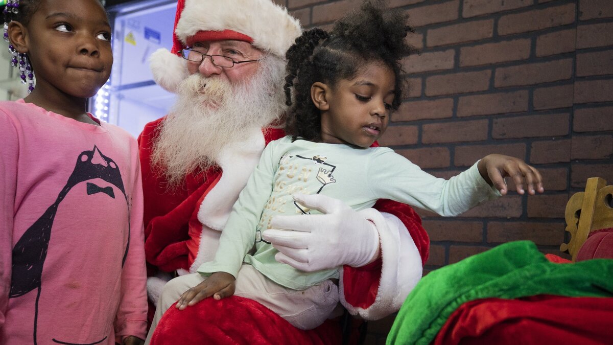 Alivea Mitchell, 5, and Chaori Hughes, 3, talk to Santa during the Wichita Police Department Holiday Feast at Pig in Pig out BBQ on Sunday. (Dec. 16, 2018)