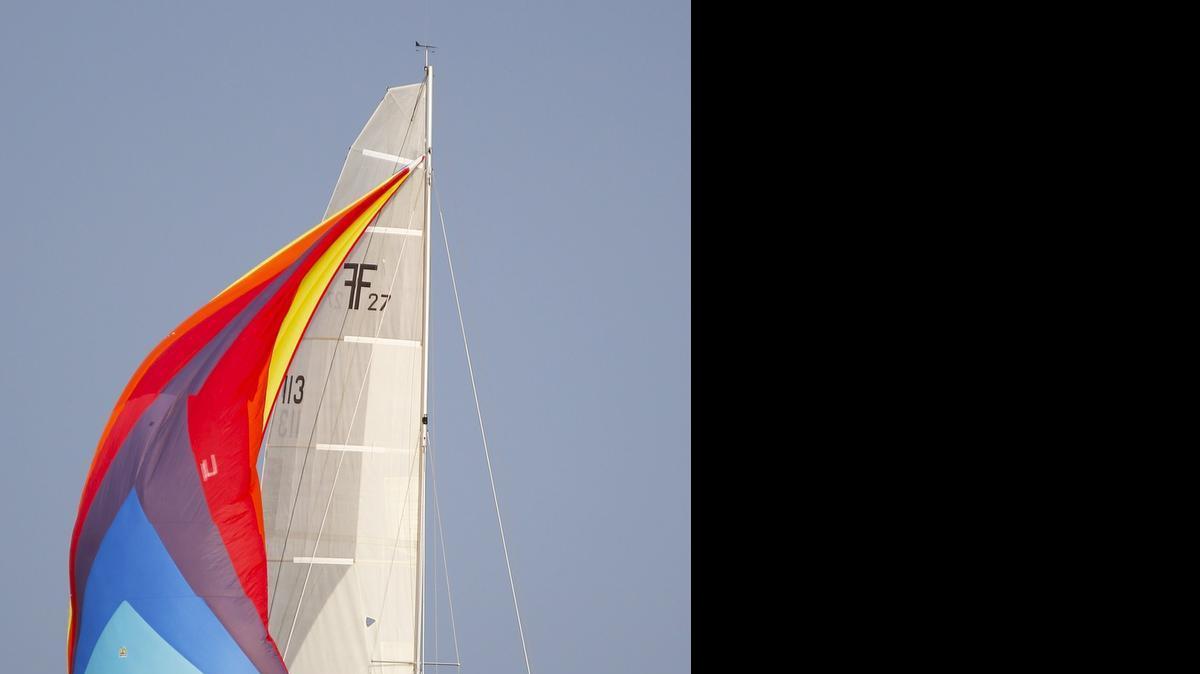 
Ninnescah Sailing Association member Larry Greenwood and his crew sail his trimaran, the “Ninnescah Flyer,” during the weekly sailing race Wednesday at Cheney Reservoir. (June 17, 2015) 
