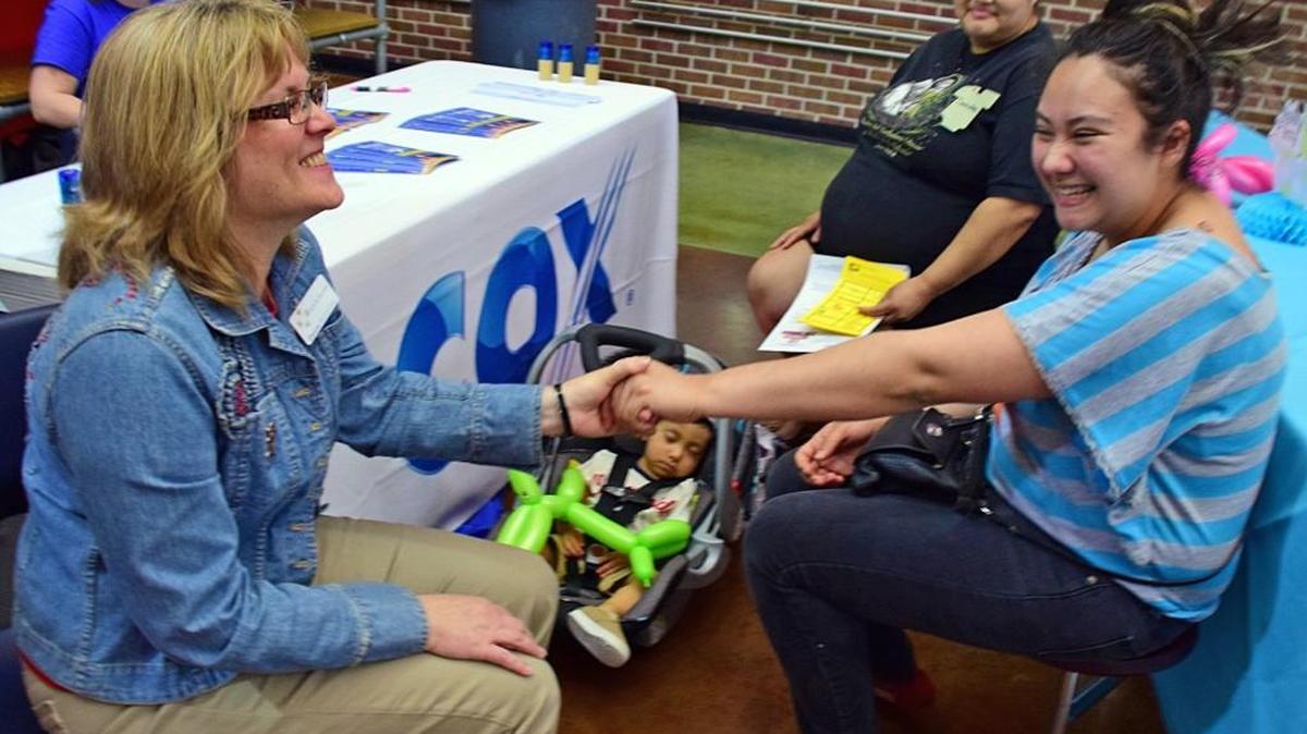 Evelyn Valladares, right, reunites with Debbie Entz, left, of Choices Medical Clinic at a community baby shower Saturday at the Boys & Girls Club. Entz helped Valladares through her pregnancy with her son, and Valladares brought her pregnant sister Sandra to the shower.